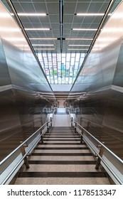 Staircase sided by two automatic escalators leading down to the main exit of the shopping mail