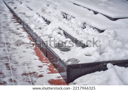 Stairs covered with snow, risk of falling on slippery stairs. Snow and ice covered stair case in winter season. Slippery snowy steps, dangerous winter walking, risk of injury
