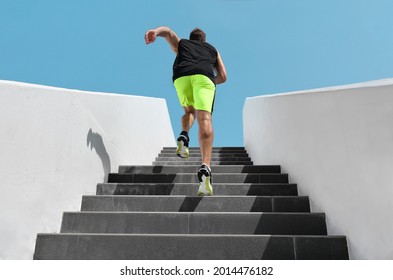 Stairs exercise fitess man running fast up the staircase for hiit cardio workout run at outdoor gym. Sport active athlete lifestyle training legs muscles. - Shutterstock ID 2014476182