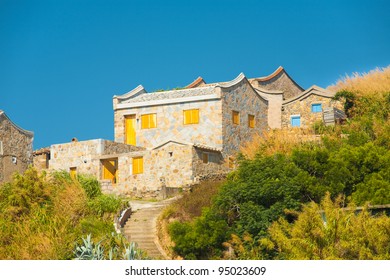 Stairs Lead To A Beautifully Constructed Traditional Fujian Style Brick House On Juguang Island On The Matsu Islands In Taiwan On A Clear Sunny, Blue Sky Day. Horizontal Copy Space