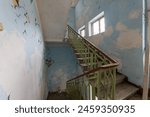 Stairs with metallic rail in abandoned building. Stairway inside an old house.