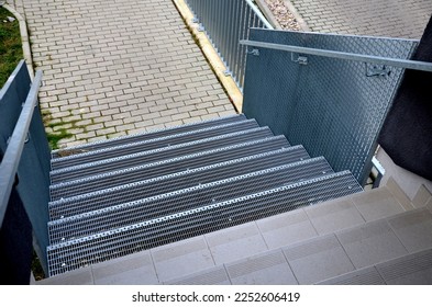 Stairs to a residential building made of stainless steel grid. galvanized stair grating made of expanded metal. lawn concrete sidewalk.  - Shutterstock ID 2252606419