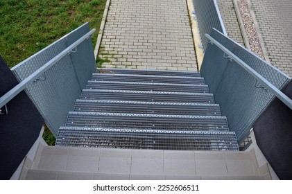 Stairs to a residential building made of stainless steel grid. galvanized stair grating made of expanded metal. lawn concrete sidewalk.  - Shutterstock ID 2252606511