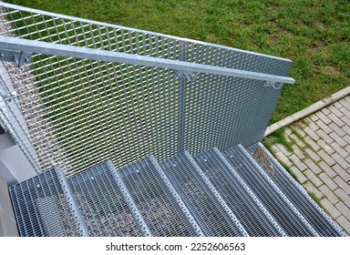 Stairs to a residential building made of stainless steel grid. galvanized stair grating made of expanded metal. lawn concrete sidewalk.  - Shutterstock ID 2252606563