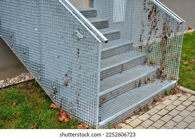 Stairs to a residential building made of stainless steel grid. galvanized stair grating made of expanded metal. lawn concrete sidewalk.  - Shutterstock ID 2252606723