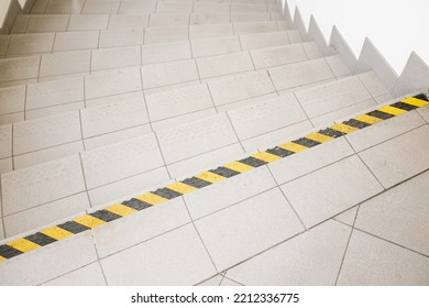 stairs with a warning sticker with yellow and black stripes