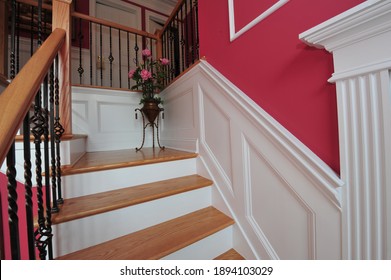 Stairs With White Wainscoting And Iron Balusters, Finish Carpentry