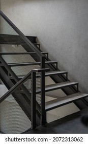 Stairway with black metal grille structure banister building architecture loft-style railings interior design contemporary. Modern home and living building steel stairway retro concept.