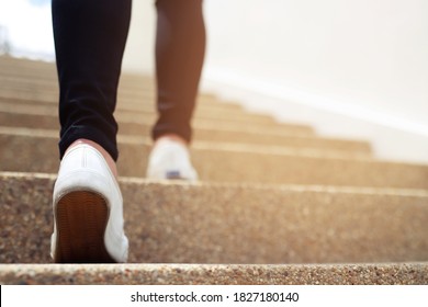 stairway. Close up legs and shoes sneakers of young woman one person walking stepping going up the stairs in modern city, success, grow up. 