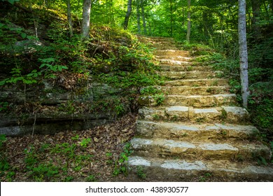 Stairway To Heaven. Winding stone stairway encased in light disappears into a lush green forest. Carter Caves State Park. Olive Hill, Kentucky. - Powered by Shutterstock