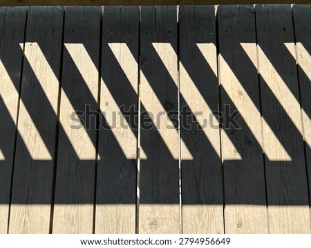 Stairways and steps collection. Sharp shadow of rails on old wooden floor.
