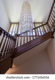 Stairwell With Chandelier And Wooden Handrail