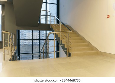 Stairwell in a modern building. Staircases as an emergency evacuation exit from the building in case of fire or emergency. Clean stairs and railings in the business center.