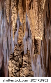 a stalactite and a stalagmite growing and being close to meeting to form a column in a cave