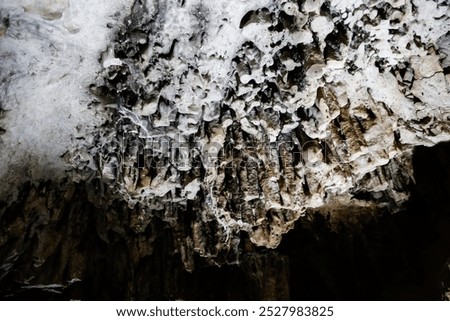 stalactites in deep cave, of different sizes and colors