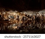 Stalactites and stalagmites reflected in calm waters inside Luray Caverns, Virginia.