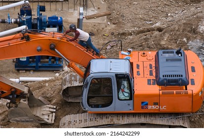 Stamford, Connecticut USA - June 25, 2021:Tender Cleaning Arm Of Hitachi EX 203 Excavator At True North Job Site In Downtown Stamford.