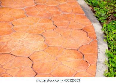 Stamp Concrete Texture Pattern And Background, Green Meadow Divided By Rough Stone Walkway,Stamped Concrete.Close Up Stamp Concrete.