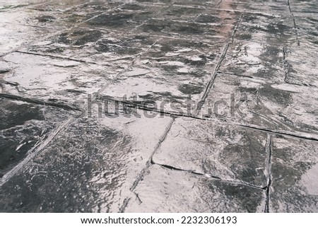 Stamp concrete texture pattern and background, and reflection of sunlight on the floor. Dark grey fresh stamp concrete.
