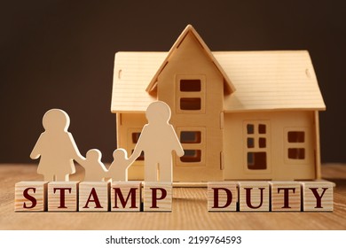 Stamp duty. Family and house wooden figures on table - Shutterstock ID 2199764593