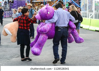 Stampede. Calgary. Alberta. Canada. July 5 2018.  A Matured Couple Scored 3 Major Trophy Prizes In Stampede.  Midway Games Are Not Just For Teens.