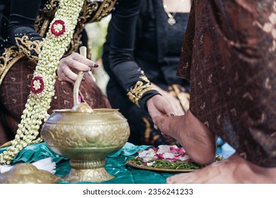 Stampede Egg Ceremony in Javanese wedding. Groom breaks an egg using foot, signifies that he's ready to be a responsible head of family. The bride washes groom's foot as a symbol of support loyalty. - Powered by Shutterstock