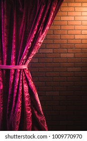 Stand Up Comedy Background, Red Curtain And A Brick Wall With A Reflector Spotlight, High Contrast Image