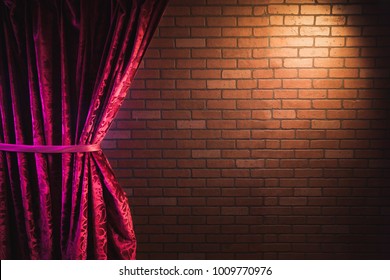 Stand Up Comedy Background, Red Curtain And A Brick Wall With A Reflector Spotlight, High Contrast Image