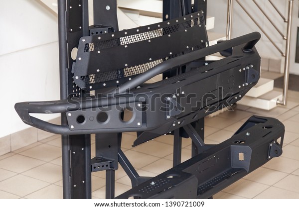 Stand for demonstration of car body elements\
reinforced for off-road and made of metal, such as bumper, steps\
and black grille in the workshop for the installation and tuning of\
SUV vehicles.