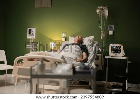 Stand filled with medicines, with a background featuring a man lying in a hospital room, slightly out of focus.