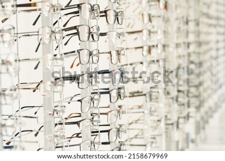 Stand with glasses in the store of optics. Showcase with spectacles in modern eyeglasses shop