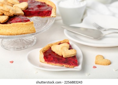 Stand and heart-shaped plate with sweet strawberry pie and cookie hearts for Valentine's day on white table