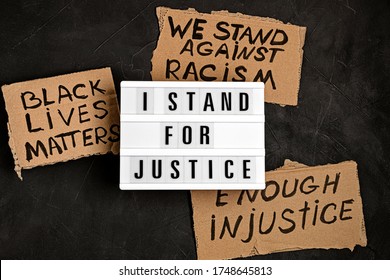 I Stand For Justice Text On Light Box And Other Anti Racism Slogans Over Dark Background