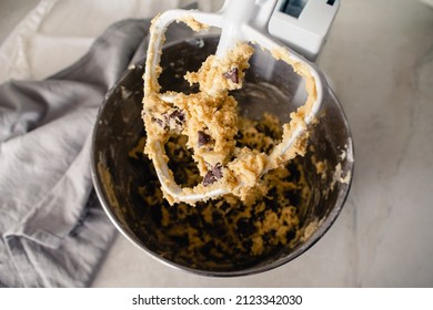 Stand Mixer Paddle Attachment Covered in Cookie Dough: Closeup view of a stand mixer beater covered in chocolate chip cookie dough