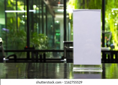 Stand Mock Up Acrylic Tent Card Menu Frame On Wood Table In Restaurant Background. Point Of Purchase Advertising Concept.