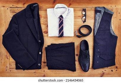 Stand out in the workplace with this stylish outfit. High angle shot of a stylish business outfit laid out on a wooden table.