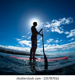 Stand Up Paddle Boarder Exercising In The Ocean