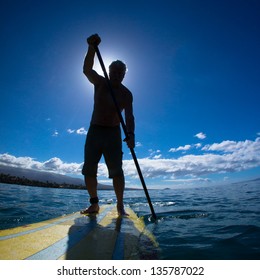 Stand Up Paddle Boarder Exercising In The Ocean