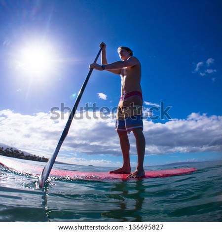 Stand up paddle boarder exercising in the ocean
