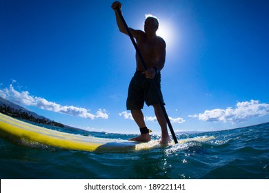 Stand Up Paddle Boarder Paddling Off The Coast Of Maui, Hawaii 