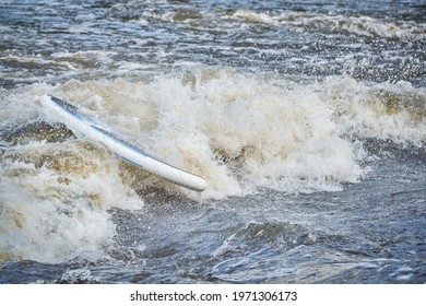 Stand Up Paddleboard With A Paddler Under Water After Running Rapids In The Poudre River Whitewater Park.