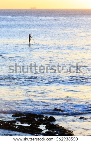 Stand Up Paddling in the Ocean during Sunset 