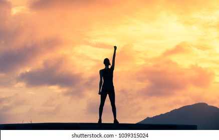 Stand strong. Woman with fist in the air. Feeling motivated, strength and courage concept. 