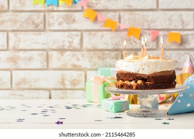 Stand With Tasty Birthday Cake And Confetti On Light Table