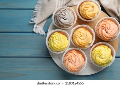Stand With Tasty Cupcakes On Light Blue Wooden Table, Flat Lay. Space For Text