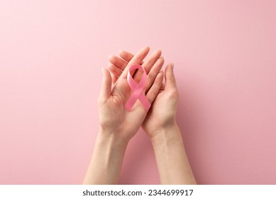 Stand together for International Breast Cancer Awareness Month. Top view of female hands with pink ribbon on pastel pink isolated background, providing copyspace for text or ad including - Powered by Shutterstock