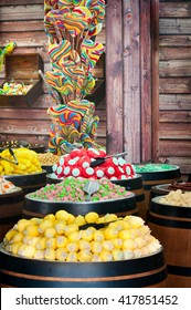 A stand with wide assortment of multicolored candy on a wooden background - Shutterstock ID 417851452