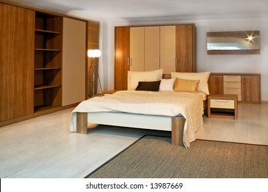 Standard Bedroom In Apartment With Wooden Furniture