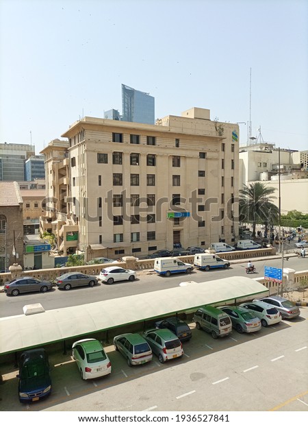 The standard chartered bank building in front of the\
habib bank plaza with a parking area in front  - Karachi Pakistan -\
Mar 2021