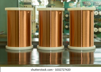 Standard Copper Wire Enamel In A Bobbin On The Table, Steel Floor In The Factory. The Backdrop Is A Machine. Winding Machine